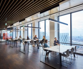 colleagues discussing employee engagement and wellbeing on separate tables in workspace